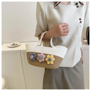 Détail d'un sac seau tissé à la main avec fleurs en 3D et design bicolore élégant