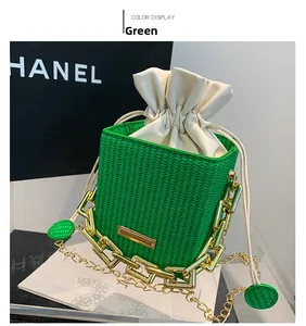 Detail of green woven bucket bag with cream drawstring and gold chain handle