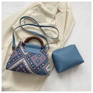 Detail of bohemian weave handbag with wooden handle and matching blue inner pouch