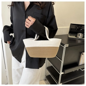 Détail d'un sac cabas tissé bicolore avec un design en paille tressée blanche et marron