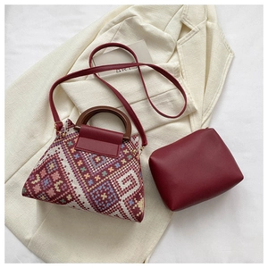 Detailed view of ethnic embroidery handbag with wooden handles and crossbody strap