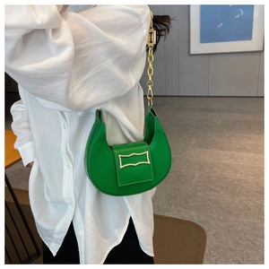 Détail du sac croissant vert vif avec boucle dorée vintage et bandoulière en chaîne