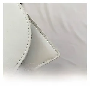 Macro di pelle bianca con cuciture precise su una borsa a tracolla stile retrò