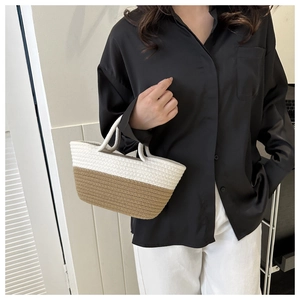 Détail du sac cabas tissé main bicolore crème et marron porté par un mannequin