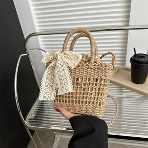Handmade woven straw summer bag with a large lace bow and versatile crossbody strap