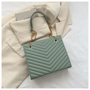 Detailed view of Morandi green tote bag with V-quilted pattern and gold chain handles
