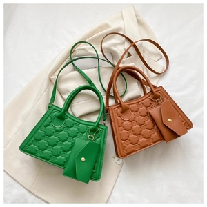 Detail of green and brown square handbags featuring quilted textures and matching mini pouches