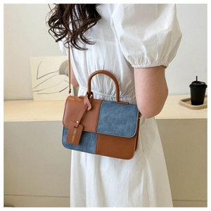 Détail du sac à bandoulière bicolore en cuir marron et patchwork de denim bleu