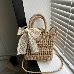 Handmade woven straw tote bag with cream lace bow and drawstring liner for summer