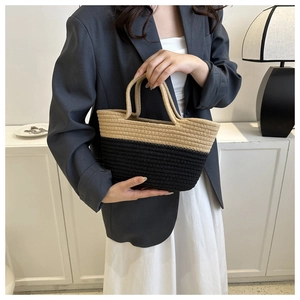 Détail du sac cabas bicolore en paille tressée beige et noir avec ses deux poignées