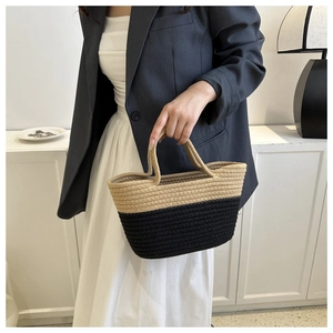 Détail d'un sac seau bicolore tissé avec des textures élégantes en beige et noir
