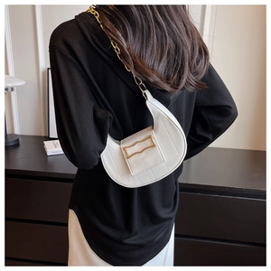 Détail du sac à bandoulière blanc en demi-lune avec chaîne dorée et boucle minimaliste