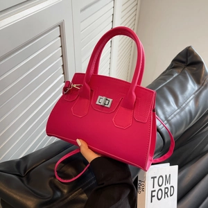 Pink minimalist handbag with silver twist lock and round handle from a side angle
