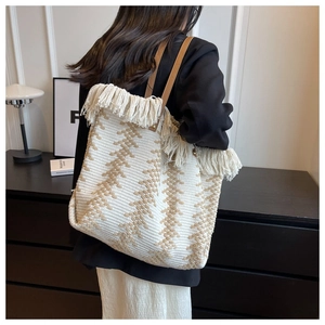 Detailansicht des gestrickten Wellenmusters und der Boho Fransen an der Tragetasche