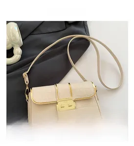 Detail of off-white small square bag with crocodile pattern and golden lock buckle