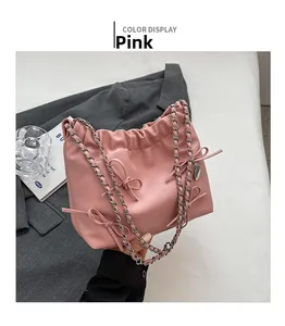 Detailed view of pink bow-knot PU leather tote bag with silver chain strap and drawstrings