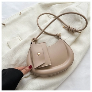 Detail of beige crescent saddle bag with adjustable strap and small matching pouch