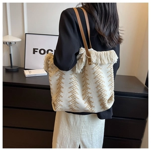Detail der gestrickten Totebag mit Fransen, Ethno-Mustern und Lederriemen