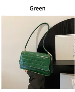 Détail du sac vert en cuir crocodile avec texture brillante et design à rabat