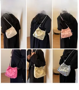 Detail of ruched bucket bag with bow and chain strap in five colors worn by models