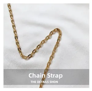 Detail of a bright golden metal chain strap with oval links for a mini handbag