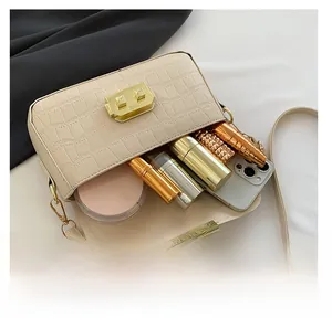 Detail of cream crocodile embossed handbag showing interior capacity for phone and makeup