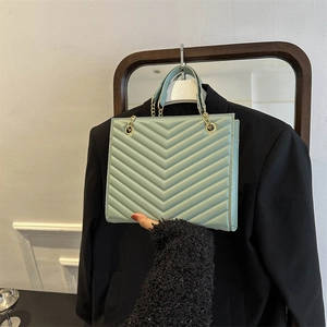 Mint green quilted tote bag with golden chain strap and leather handle in a sleek design