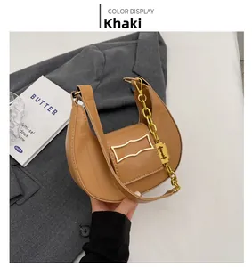 Détail du sac demi-lune kaki avec finition mate et chaîne décorative dorée vintage