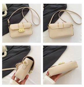 Detail view of cream crossbody bag featuring faux crocodile texture and gold metal clasp