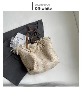 Detail of knit bucket bag with frayed tassels, geometric pattern, and leather handle