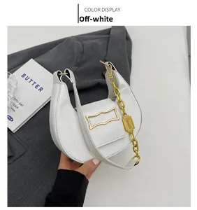 Détail du sac demi-lune crème avec chaîne dorée et fermeture à rabat magnétique