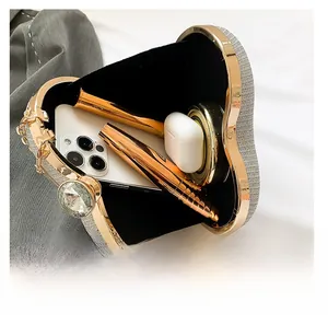 Internal view of heart-shaped clutch showing storage for phone, lipstick and earbuds