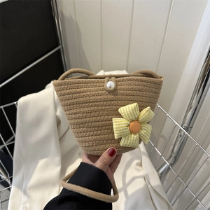 Borsa a secchiello intrecciata a mano marrone con chiusura a perla e ciondolo a fiore