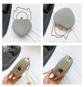 Detail view of heart-shaped evening bag with gold ring handle and glitter texture