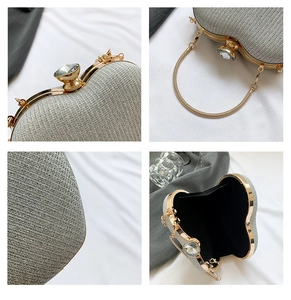 Detail of silver glitter heart bag with gold chain, crystal clasp and macro texture