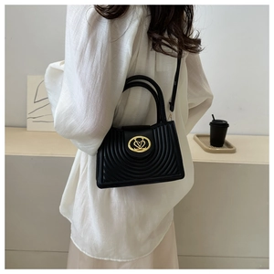 Detail of black crossbody bag with semi-circular quilting and golden V-heart lock