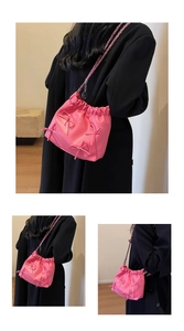 Detailed view of pink pleated handbag with silver chain strap and decorative bows