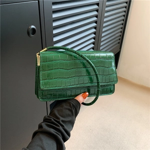 Sac à main vert avec motif crocodile, design minimaliste brillant et poignée incurvée chic