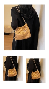 Detail of camel leather bucket bag with pleated design and elegant bow accents