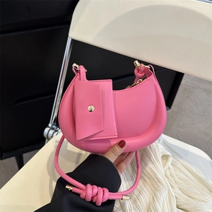 Pink crescent shoulder bag with a matching mini pouch and stylish woven cord strap