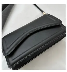 Detail showing high-quality black leather square bag with elegant stitching and metal hardware
