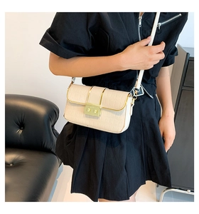 Detail of cream crossbody bag with faux crocodile pattern and gold buckle clasp