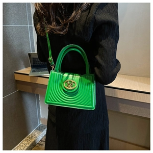 Detail van de felgroene gewatteerde handtas met gouden logo en bijpassende schouderriem