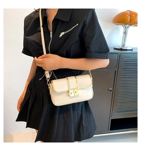 Close-up of ivory faux crocodile leather shoulder bag with gold metal lock buckle