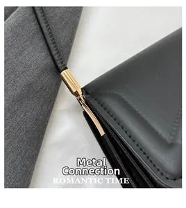 Detailed close-up of light gold metal hardware and stitching on black leather bag