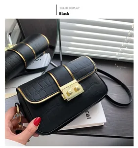 Detail view of black crocodile pattern shoulder bag with a gold metal square lock