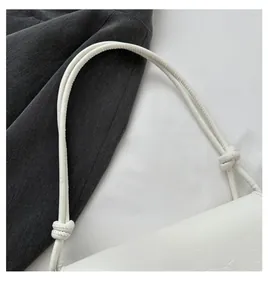 Gros plan d'un sac blanc à motif crocodile avec poignée nouée et cuir PU texturé