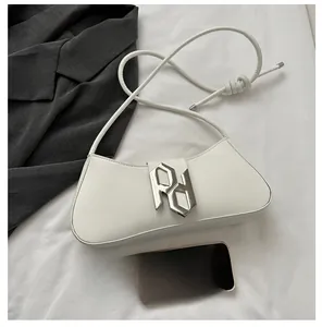 Detail view of the silver PD metal logo on a white leather crescent underarm bag