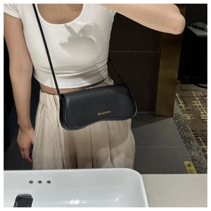 Détail d'un sac à bandoulière noir en relief crocodile avec logo doré pour femme