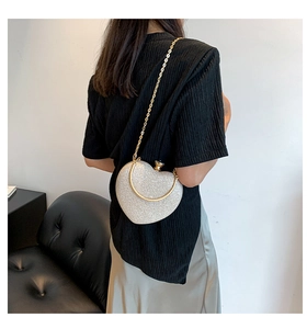Détail du sac à main cœur argenté brillant avec bandoulière chaîne dorée et poignée